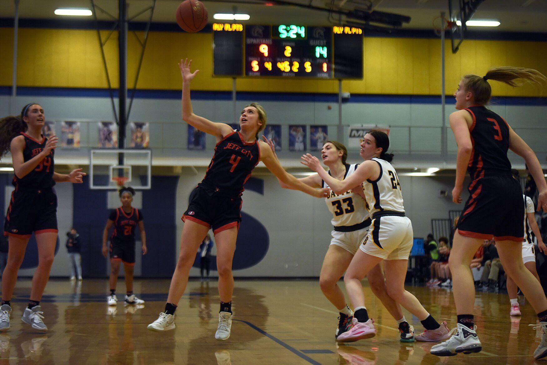 Jefferson City’s Regan Nilges 4 ,left, swats away the ball from opposing Battle players